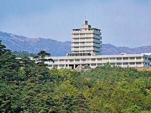 生駒の山並みを背景にした一号館遠望